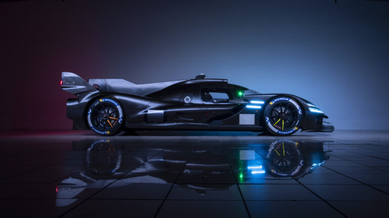 The Genesis Magma Racing GMR-001 Hypercar showin in profile, with black livery, against a black backdrop
