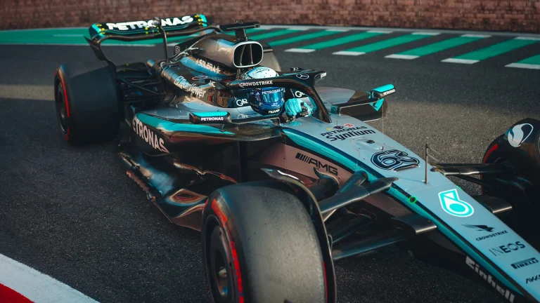 A close up of a Mercedes AMG Petronas F1 W16 race car takes a turn on a motorsport track