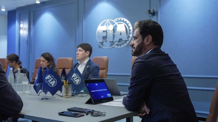 The FIA World Motor Sport Council sat at a table with the FIA logo on the wall
